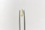 A natural geometric marquise portrait cut yellow sapphire available to add as a center stone for your heirloom setting at The North Way Studio. A warm, pale yellow with hints of sunshine. The sapphire is shown held up by tweezers on a white background.