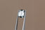 A natural cushion cut steely gray spinel available to add as a center stone for your heirloom setting at The North Way Studio. A steely blueish gray reminiscent of a stormy day. The spinel is shown held up by tweezers.