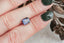 Large purple emerald cut natural spinel shown on a hand