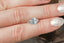 A large opalescent light blue and pale yellow shield cut sapphire shown on a hand