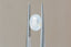 A natural oval opalescent pale blue sapphire available to add as a center stone for your heirloom ring setting at The North Way Studio. Silken pale blue, so faint it's nearly white, churns with peaches and sunlit hues. The sapphire is shown tilted to the side and held with tweezer.
