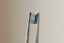 A natural emerald cut teal sapphire available to add as a center stone for your heirloom setting at The North Way Studio. A deeper forest teal hue. The sapphire is shown held up with tweezers.