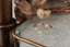 The North Way Studio's Reverie Diadem Luxe band featuring a crown of baroque leaves and diamonds that taper into a sleek band. Encrusted with six tiny white diamonds and a prominent center diamond, all set in your choice of reclaimed gold. The ring forms a delicate 'V' contour. Shown from afar facing left atop a white marble tabletop.