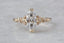 A customizable solitaire fantasy engagement ring setting with small brilliant cut diamonds set into leaf prongs. Shown in reclaimed 14 karat yellow gold with a lab grown marquise diamond. Elven fairytale engagement ring designed by The North Way Studio.