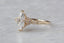 This fantasy solitaire engagement ring setting by The North Way studio features vines of reclaimed gold unfurling about genuine diamond dewdrops and a center stone chosen by the customer. This custom engagement ring is shown in 14 karat gold with a marquise diamond center facing the viewer's left.
