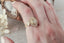Natural diamond marquise leaves and a graduated diamond halo are set in reclaimed 18 karat yellow gold around an antique old European cut diamond. Ready to ship antique inspired flower engagement ring, size 6. Shown on the hand.