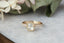 An antique inspired solitaire engagement ring. A warm yellow rose cut diamond and brilliant cut diamond dewdrop shoulders are set in 14 karat yellow gold with a velvety satin finish. This vintage inspired ring features an organic milligrain edge and delicately hand-carved leaves on the setting walls. Ready to ship, size 6. Crafted by The North Way Studio in collaboration with Claire Pettibone.