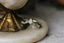 A dramatically tapered ring with leaves and a rustic carved band is topped with a pear cut diamond. Designed by The North Way Studio and shown here in white gold.