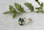A fantasy engagement ring featuring a dark forest green natural oval brilliant cut sapphire, two marquise diamonds, and hand-carved leaf and bark texture in reclaimed 18 karat white gold. This fairytale garden engagement ring is ready to ship, size 6 1/2. Crafted by The North Way Studio in collaboration with Claire Pettibone.