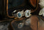 Two variations of this custom engagement ring setting designed by The North Way Studio are shown resting in an antique jewelry box. A halo of diamonds surrounds the sapphire center stones and whittled bark textures and leaves are carved into the 14 karat white gold rings.