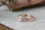 An antique inspired engraved engagement ring setting, customizable with choice of reclaimed fine gold and center jewel. Shown in 14 karat rose gold with lab grown oval diamond.