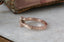 An antique inspired engraved engagement ring setting, customizable with choice of reclaimed fine gold and center jewel. Shown in 14 karat rose gold with lab grown oval diamond.