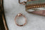 An antique inspired engraved engagement ring setting with hidden diamonds, customizable with choice of reclaimed fine gold and center jewel. Shown in 14 karat rose gold with lab grown oval diamond.