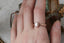 A Victorian inspired engraved engagement ring setting, customizable with choice of reclaimed fine gold and center jewel. Shown in 14 karat rose gold with lab grown oval diamond and on the hand.