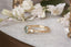 A natural Montana teal green sapphire and two natural marquise diamonds are set in 18 karat yellow gold in this nature inspired engagement ring. This ring features hand-carved gold leaves and bark texture. Ready to ship antique inspired alternative engagement ring, size 7.