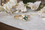 A natural Montana teal green sapphire and two natural marquise diamonds are set in 18 karat yellow gold in this nature inspired engagement ring. This ring features hand-carved gold leaves and bark texture. Ready to ship antique inspired alternative engagement ring, size 7.