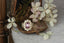 A flower engagement ring in natural pink spinel with diamond halo and sapphire leaves, hand carved leaves and bark texture in 18 karat yellow gold.