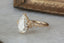 This custom heirloom engagement ring setting designed and crafted by The North Way Studio features delicate leaves carved in reclaimed gold and a cluster of diamond dew drops spun about your choice of center gemstone. This fantasy ring is shown in 14 karat yellow gold with a large pear cut diamond center.