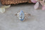 Pear cut light blue sapphire engagement ring with marquise diamond accents. Ready to ship in reclaimed 18 karat white gold.