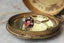 Marquise diamonds and unfurling carved gold leaves nestle a uniquely chosen center stone in this heirloom fantasy engagement ring setting designed and crafted by The North Way Studio. This ethereal three stone engagement ring is shown cast in 14 karat yellow gold with an oval deep berry spinel center.