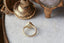 A timeless fairytale alternative engagement ring crafted by The North Way Studio. This fantasy inspired solitaire ring features hand-carved leaf details, claw prongs, and a custom center stone. The customizable ring is shown in reclaimed yellow gold and lab grown oval diamond. Shown facing away, with focus on the hand-carved details and showing the inside of the setting.
