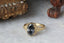 A timeless fairytale alternative engagement ring crafted by The North Way Studio. This gothic architecture fantasy inspired solitaire ring features hand-carved leaf details, claw prongs, and a custom center stone. This ready to ship ring is cast in reclaimed yellow gold and a natural fancy dark gray diamond center.