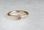 A solitaire ring inspired by antique collet settings in 14 karat yellow gold and a natural rose toned sapphire