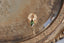 A small gold charm with natural green tourmaline and hand-carved leaf details.