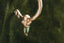 A small gold charm with natural green tourmaline and hand-carved leaf details. Shown hanging on The Fae Hoop earring.