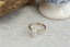 A custom fantasy engagement ring setting with leaf prongs and three diamond clusters. Shown in lab grown marquise diamond and yellow gold.