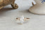 A customizable fantasy engagement ring setting with leaf prongs and three diamond clusters. Shown in lab grown marquise diamond and yellow gold.