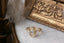 Three stone fantasy engagement ring featuring oval lab grown diamonds and medieval inspired engravings in reclaimed fine gold. A customizable engagement ring designed and crafted by The North Way Studio. This enchanting ring is shown in 14 karat yellow gold.