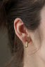 Everyday solid gold wide hoop earrings shown on the ear.