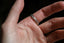The Gate band is an intricately hand-carved wedding band of woven leaves and arch ways, wrought into reclaimed golds, designed by The North Way Studio. Shown here on a man's first finger.