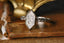 A three stone diamond everyday fantasy ring with engraved unicorn and trees on a reclaimed 14 karat gold shield.