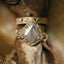 Front view of a white and grey diamond ring with a kite-shaped diamond in the center, a rough medieval fantasy-style gold band with engravings, placed on top of an antique fabric pillow.