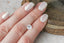 Natural white opalescent round sapphire shown on a hand