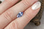A 2.03 carat medium periwinkle blue shield cut sapphire shown on a hand