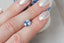 A silky pale blue opalescent sapphire shown on a hand
