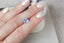 A silky pale blue opalescent radiant cut sapphire shown on a hand