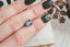 Large purple emerald cut natural spinel shown on a hand