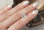 An opalescent light blue and pale yellow shield cut sapphire shown on a hand