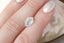 An ethereal pale blue and hazy white opalescent hexagon sapphire shown on a hand