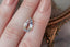 An ethereal blend of pale yellow and soft silvery blue hues in a modified pear cut sapphire.  This 2.59 carats Sri Lankan sapphire is available for purchase alongside an heirloom setting at The North Way Studio. The sapphire is shown resting on a woman's fingers for size reference.