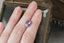 A natural oval light purple and pink sapphire available to add as a center stone for your heirloom ring setting at The North Way Studio. A lovely pale lilac pink with perhaps a hint of opalescence at some angles. The sapphire is shown resting on a woman's hand for size reference.