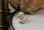 A solitaire engagement ring setting with hand-carved leaves and elongated shield shaped gold halo. 