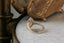 A solitaire engagement ring setting with hand-carved leaves and elongated shield shaped gold halo. 