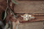 A diamond engagement ring designed and crafted by The North Way Studio in collaboration with Claire Pettibone and cast in reclaimed 14 karat gold is shown sitting atop a weathered book.