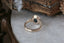 A large blue sapphire sits in the middle of this ready to ship engagement ring designed by The North Way Studio shown facing away from the viewer. A halo of diamonds surrounds the center stone. The band is hand-carved reclaimed gold.