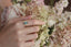 Petite sapphires of mismatched blush and berry tones are woven about a lush teal green sapphire, cocooned in rustic whittled gold in this ring designed by The North Way Studio in collaboration with Claire Pettibone and shown upon a hand.